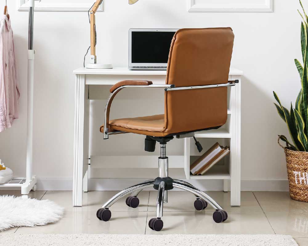 feature with Modern office setup with a black and orange ergonomic chair on caster wheels in front of a wooden desk with a computer and office supplies.